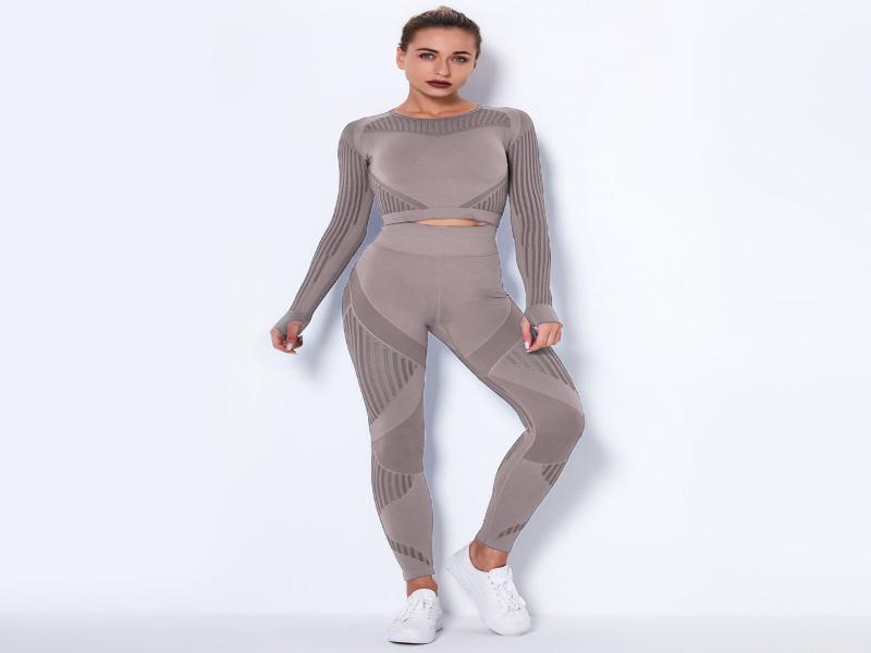 Frau im nahtlosen khakifarbenen Fitness-Outfit mit langen Ärmeln und Leggings, ideal für sportliche Aktivitäten.
